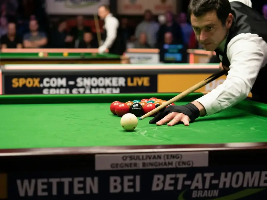 Snooker-Queue auf grünem Filz mit roten Kugeln in Dreieck-Formation